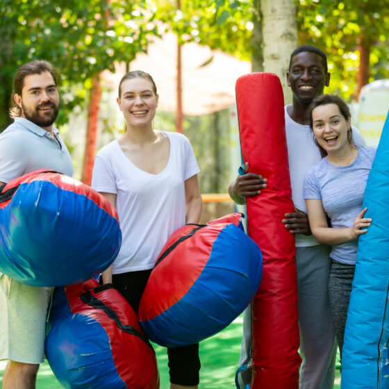 4 jeunes en Formation animation BPJEPS LTP, heureux, avec des billes et des coussins gonflables dans un parc d'attractions.