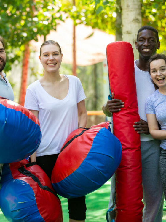 4 jeunes en Formation animation BPJEPS LTP, heureux, avec des billes et des coussins gonflables dans un parc d'attractions.