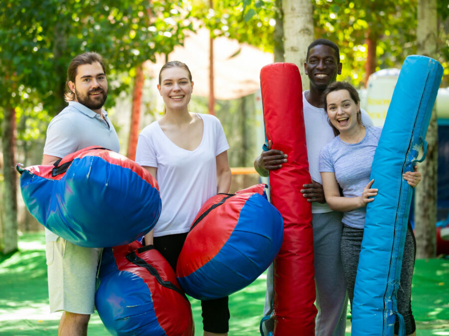 4 jeunes en Formation animation BPJEPS LTP, heureux, avec des billes et des coussins gonflables dans un parc d'attractions.